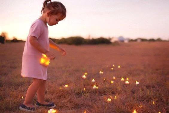 Niña recogiendo luces en el campo