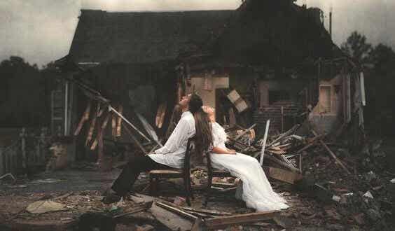 pareja ante una casa derruida