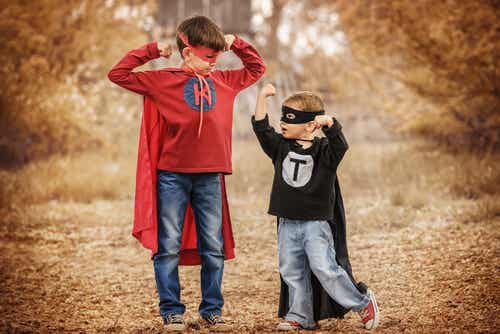 Hermano mayor y pequeño vestidos de superhéroes comparándose