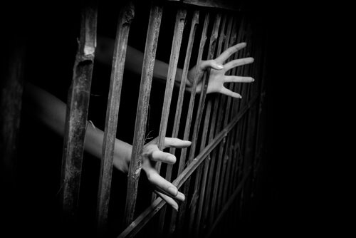 Manos de una persona en prisión