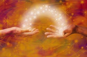 Manos unidas por un haz de luz con estrellas
