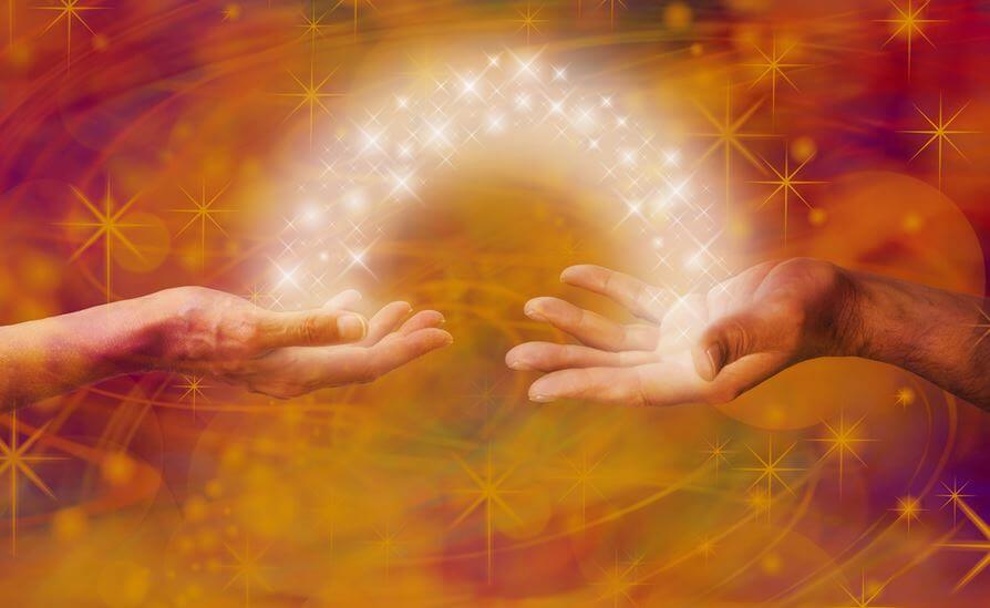 Manos unidas por un haz de luz con estrellas