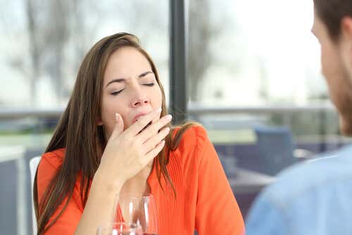 Mujer bostezando mientras habla con su compañero