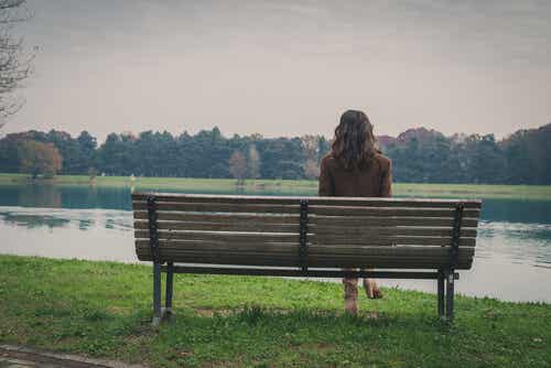 Mujer sola sentada en un banco de un parque