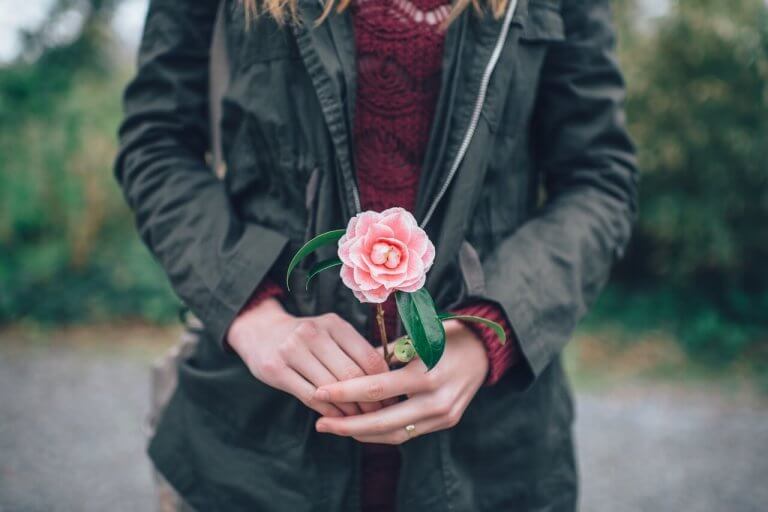 Mujer con una flor representando la sabiduría de Thich Nhat Hanh