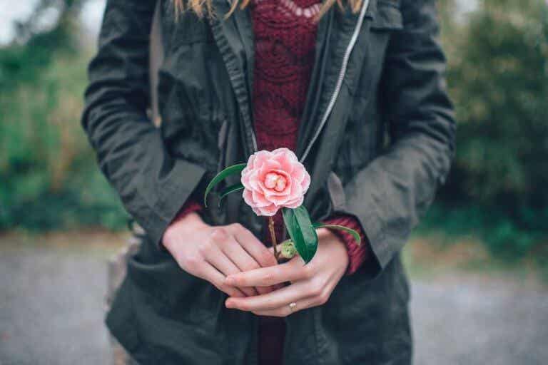 Mujer que sabe cuidarse con una flor en la mano