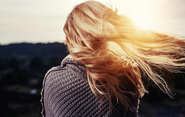 mujer rubia de espaldas triste por terminar la relación