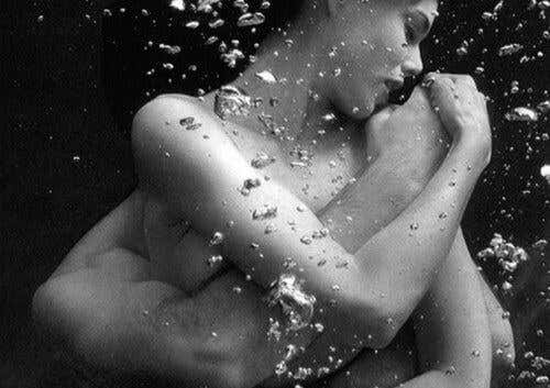 pareja abrazada debajo del agua ensalzando el amor necesitado