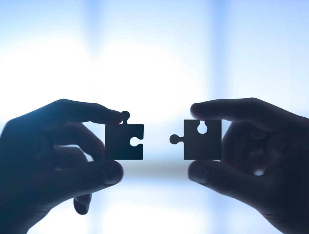 Manos con dos piezas de un puzzle
