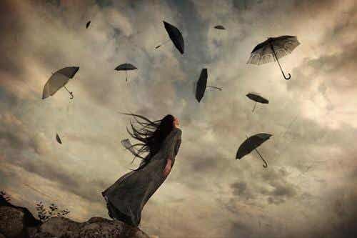 Mujer mirando a los paraguas volando en el cielo