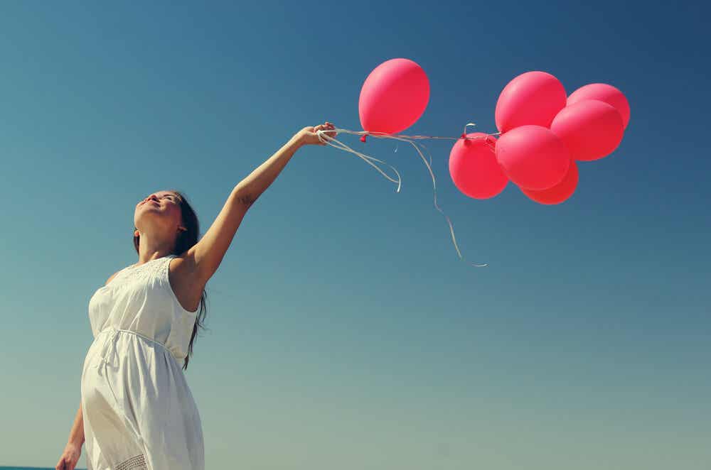 Frau feiert Behandlungsabschluss mit Luftballons