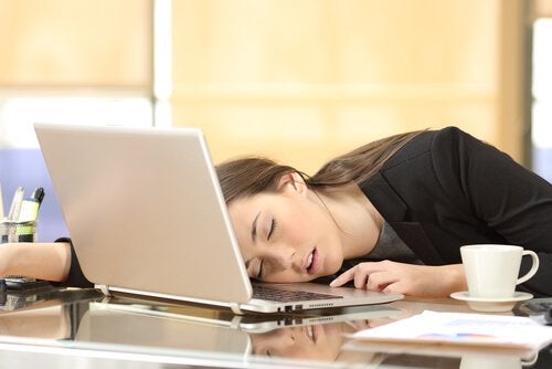 Mujer dormida en el ordenador incapaz de vencer la pereza
