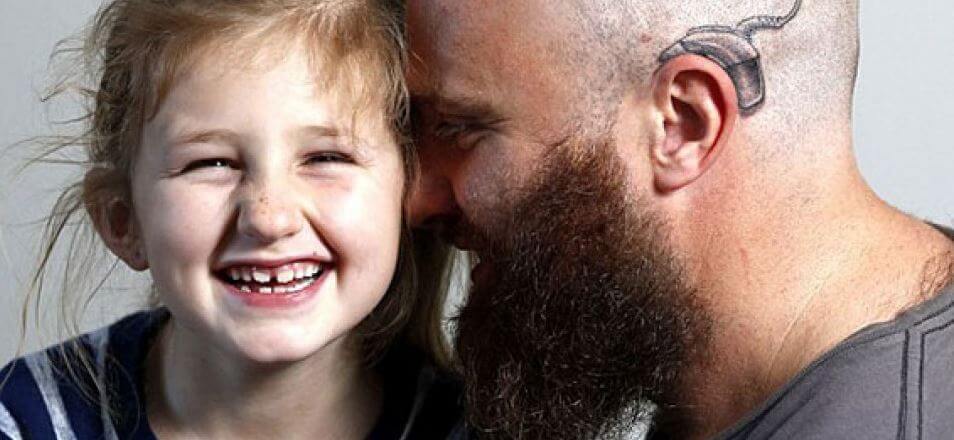 Papá e hija con implante coclear tatuado