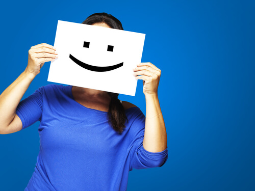 Mujer con un cartel de una cara sonriendo