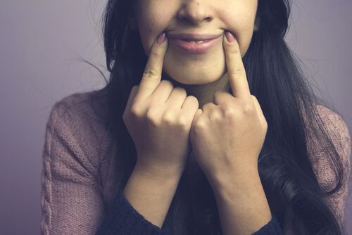 Mujer fingiendo una sonrisa
