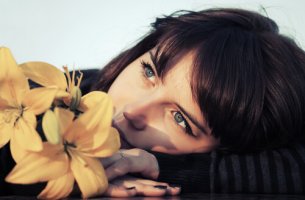 Mujer pensando con una flor sobre lo justo de la vida