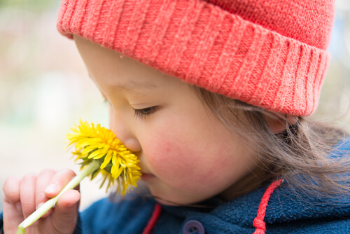 Niña oliendo una flor