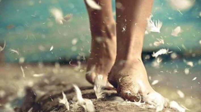 Pieds marchant sur le sable et les plumes