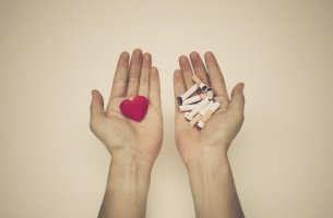 Dejar de fumar, manos con corazón y con tabaco