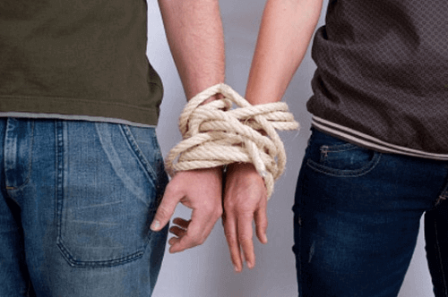 Manos de dos personas atadas