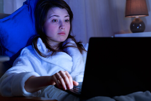 Adolescente con un portatil por la noche