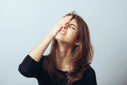 Femme avec la main sur la tête pour avoir oublié