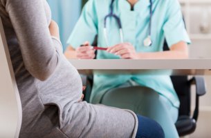 Mujer embarazada sentada en la consulta del médico