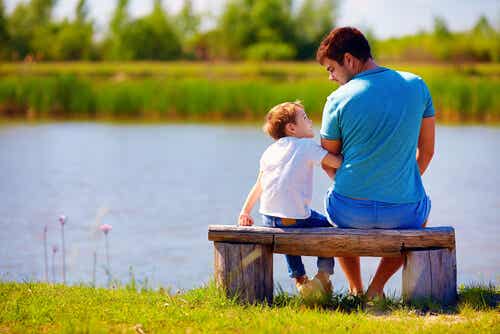 Padre hablando con su hijo sentado en un banco