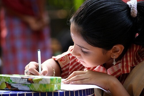 niña concentrada escribiendo