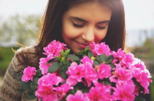 Mujer oliendo flores rosas