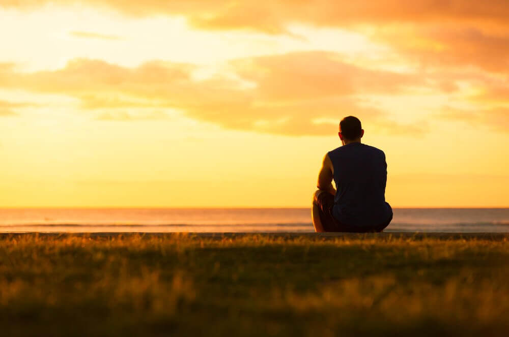 Homme seul regardant l'horizon pensant aux secondes chances