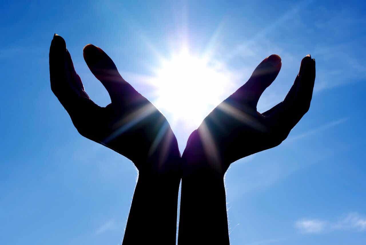 Manos abiertas al sol simbolizando la religión