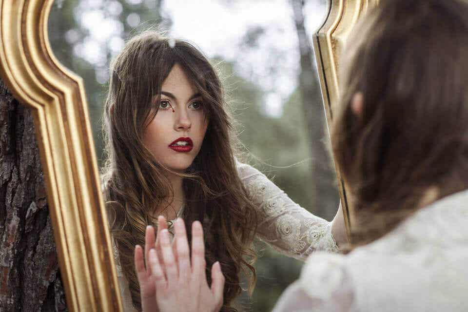 Mujer mirándose en un espejo buscando otra personalidad