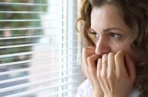 Mujer con miedomirando por una ventana