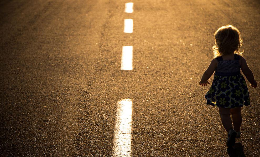 Niña andando por la carretera