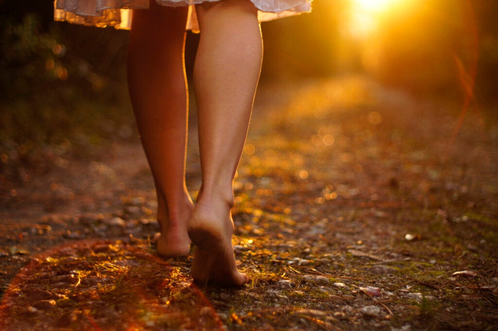 Vrouw wandelt blootvoets door het bos