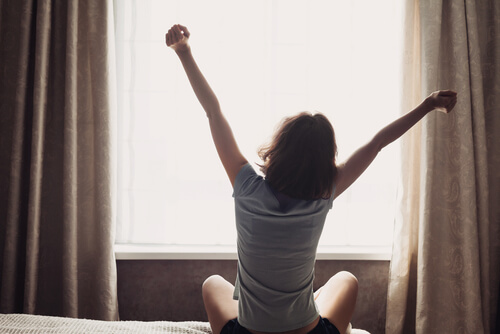 Mujer estirando los brazos al despertar