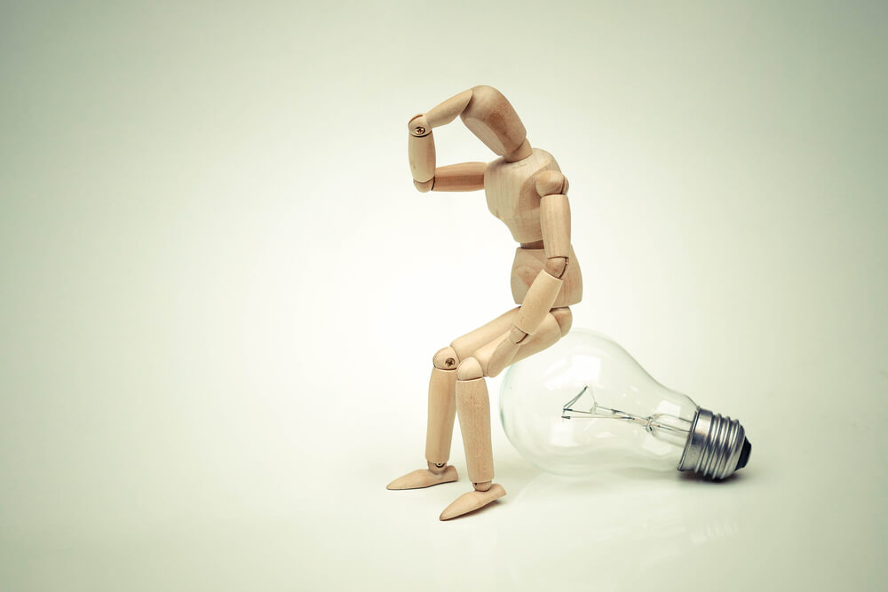 Muñeco sentado sobre una bombilla