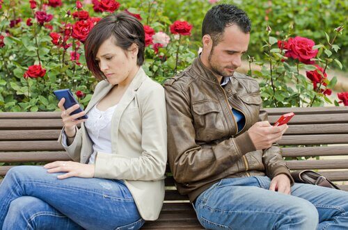 pareja de espaldas mirando móvil simbolizando el comienzo de una relación de pareja