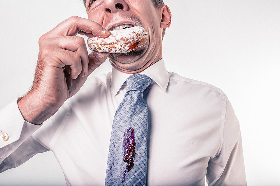hombre trajeado comiendo donut