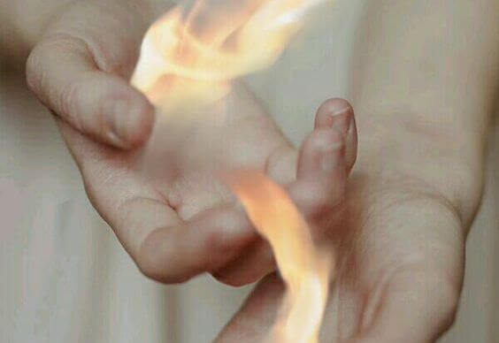 Manos con fuego representando odio