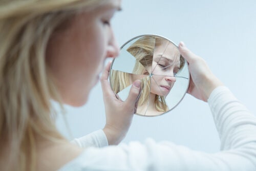 Mujer mirándose en un espejo roto