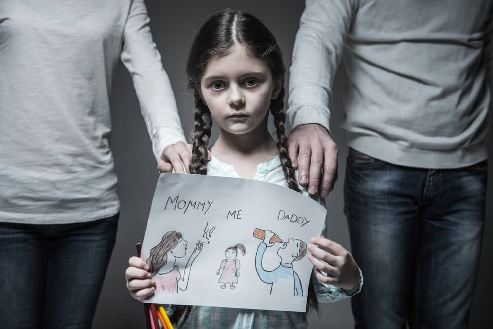 Niña con sus padres alcohólicos