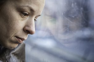Mujer triste mirando por la ventana