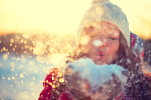 Mujer soplando nieve