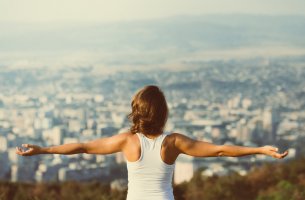 Mujer con los brazos abiertos guiándose por el principio de Pareto
