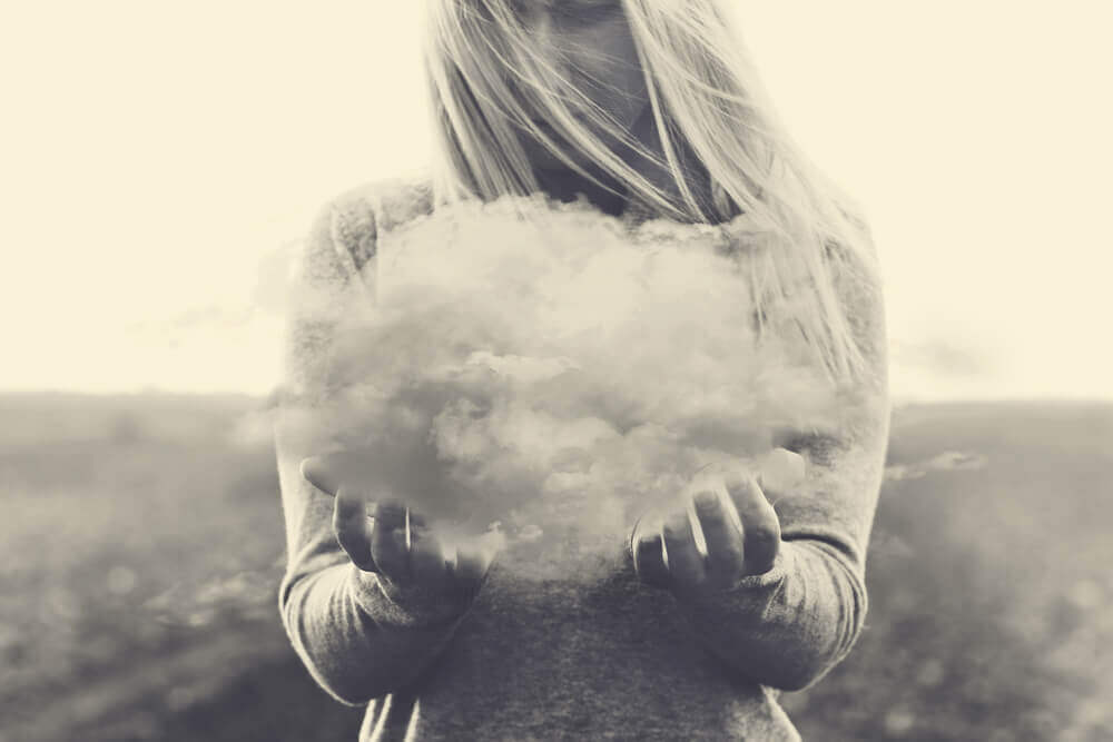 Mujer sujetando  una nube por echar de menos a alguien