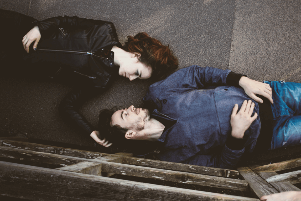 pareja tumbada en el suelo mirándose