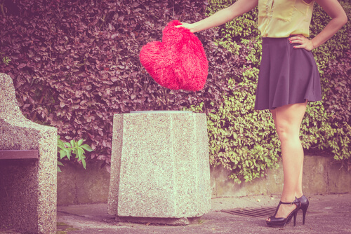 Mujer tirando un corazón a la basura