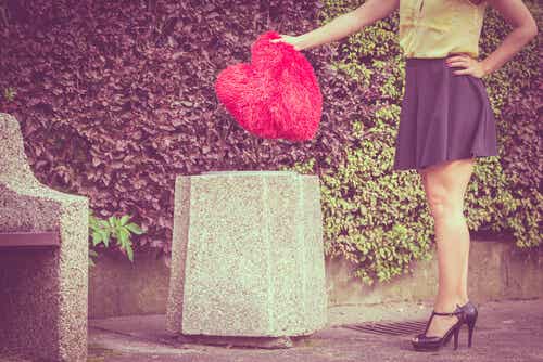Mujer tirando un corazón a la basura